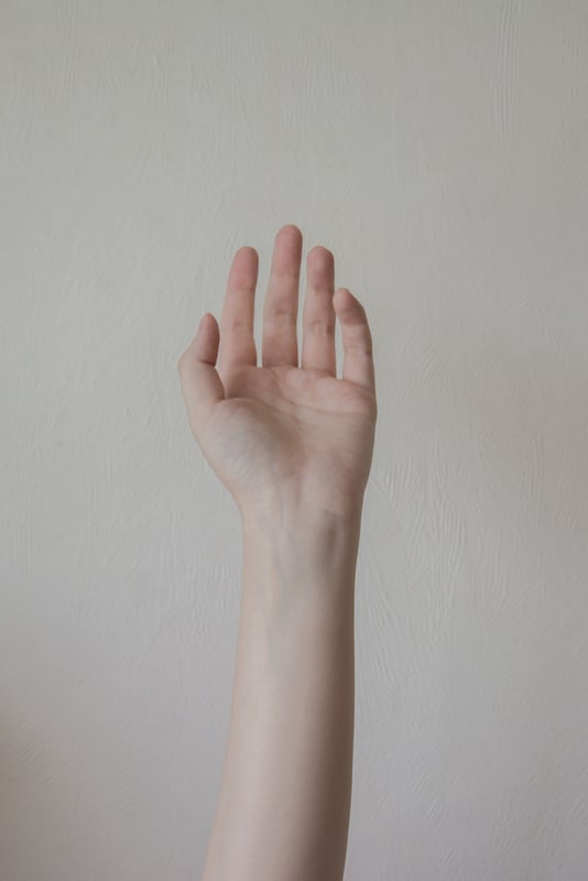 Persons Right Hand on White Wall